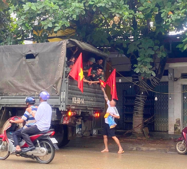             Xúc động hình ảnh người dân vùng lũ cầm cờ, hoa vẫy chào, cảm ơn các anh bộ đội    