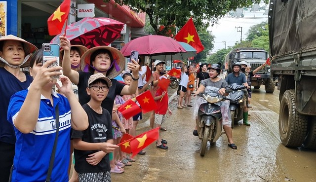             Xúc động hình ảnh người dân vùng lũ cầm cờ, hoa vẫy chào, cảm ơn các anh bộ đội    